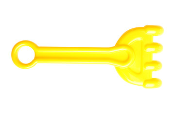 yellow plastic children's toy rake for the sandbox isolated on white background