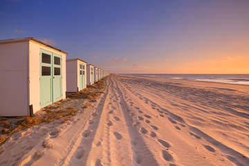 Row of beach huts at sunset, Texel island, The Netherlands - obrazy, fototapety, plakaty