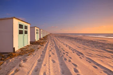 Fotobehang Rij strandhuisjes bij zonsondergang, eiland Texel, Nederland © sara_winter