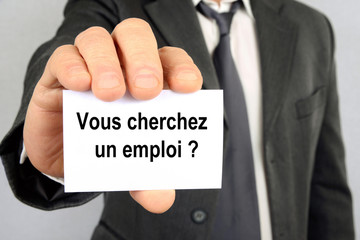 Homme tenant une carte sur laquelle est écrit vous cherchez un emploi