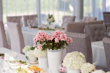pink and white flowers on a table in a cafe