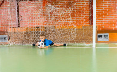 Young boy saving a goal in a soccer game
