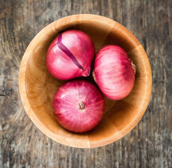 wood bowl with Red Onion on old wooden background