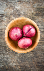 wood bowl with Red Onion on old wooden background