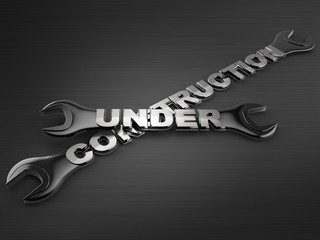under construction word with a wrench on dark background