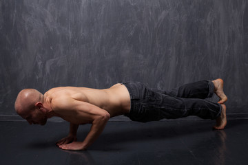 Fototapeta na wymiar Athletic man with naked torso doing push-ups.