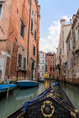 Gondola and modern ships in the narrow Venetian canals. Venice is one of the most popular tourist destinations in the world