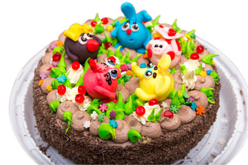 Fototapeta na wymiar Celebration colorful cake decorated with fruit, chocolate and figures of animals for kids party