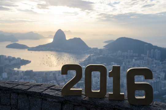 Golden 2016 sign standing at sunrise overlook view of Rio de Janeiro city skyline and Sugarloaf Mountain