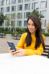 Fototapeta premium Young Woman use of the smart phone at outdoor coffee shop