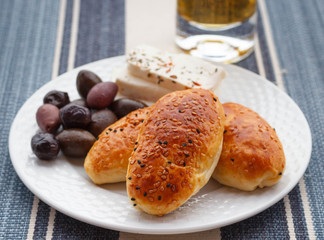 Pies with cheese and olives, sprinkled with sesame seeds
