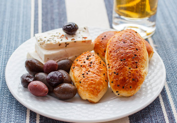 Pies with cheese and olives, sprinkled with sesame seeds