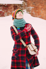 Girl in red checkered coat standing at old town background