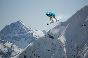Flying snowboarder on mountains