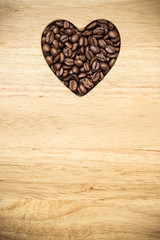 Heart shaped coffee beans on wooden board