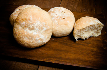 Small buns on a dark wooden background. Selective focus. Toned