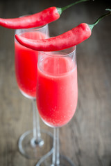 Two glasses of Mimosa cocktail decorated with chili peppers