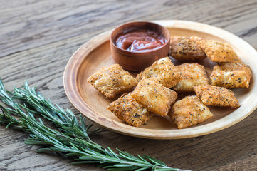Plate with fried ravioli on the wooden board