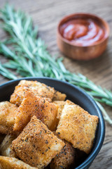 Plate with fried ravioli on the wooden board
