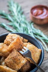 Plate with fried ravioli on the wooden board