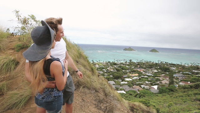 Couple tourists hiking and enjoying view from Pillbox Hike, Mokulua islands, Oahu, Hawaii.