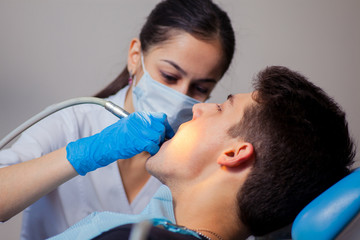 Obraz na płótnie Canvas Man having teeth examined at dentists dental treatment