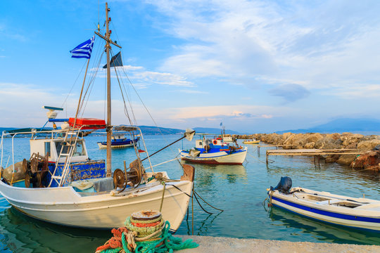 Traditional Greek fishing boats in port at sunset time, Samos island, Greece