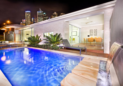 A moody and stylish image of a house pool with beautiful city be