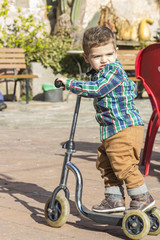 Obraz premium Cute boy rides a scooter..