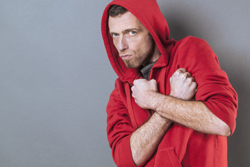 protection concept - scared 40s man standing with fists crossed on chest for rebellion and...