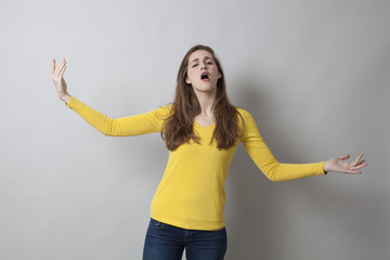 hand gesture concept - beautiful young woman expressing herself like in theatre with arms wide open,studio shot