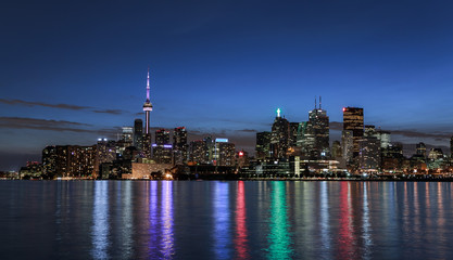 Fototapeta na wymiar amazing stunning gorgeous beautiful night view of Toronto city downtown from lake Ontario with colorful light reflections in water