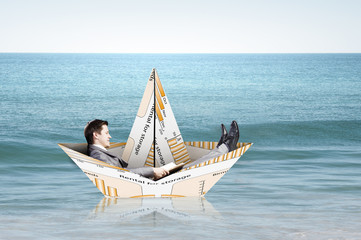 Businessman in boat made of paper