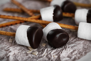 Tasty marshmallows with chocolate on sticks, close up