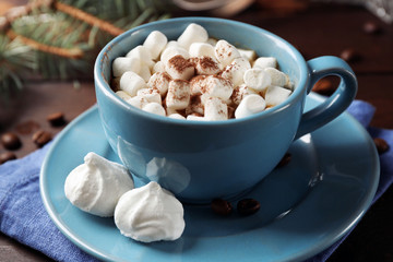 Mug of hot chocolate with marshmallows, fir tree branch on wooden background