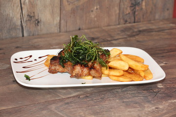 Schweinesteak mit Pommes und Salat