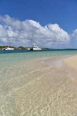 View of crystal clear Caribbean sea and boats in background