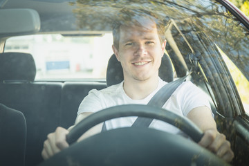 Junger Mann sitzt im Auto