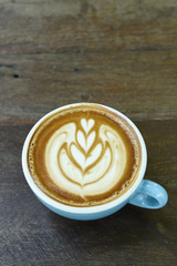 cup of latte art coffee on wooden background