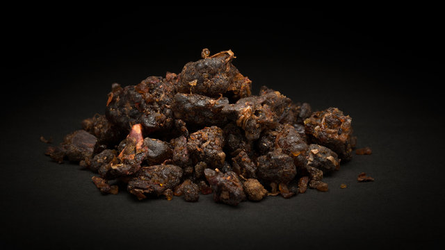 Pile of Organic Indian bdellium or Guggul resin (Commiphora wightii) on dark background.