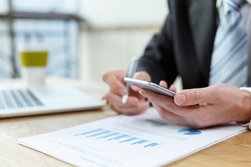 businessman checking financial reports on table