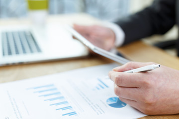 businessman checking financial reports on table