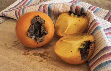 persimmon on a wooden boardv