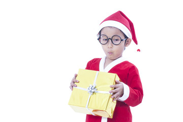 Little boy wearing Santa Claus uniform with a gift