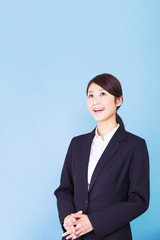 ビジネスウーマン　見上げる　ひらめく　発見　笑顔　青背景　コピースペース