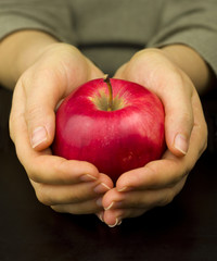 red ripe apple in her hands