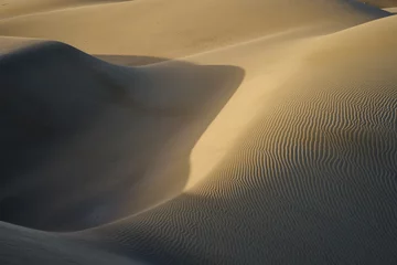 Papier Peint photo Sécheresse Dunes de sable dans le désert / Dunes de sable et ondulées aux formes élégantes dans un vaste désert sous ciel bleu