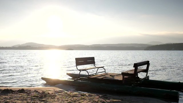 Abandoned old rusty paddle boat stuck on sand of beach. Wavy water level, island on horizon. Autumn weather at coastline 