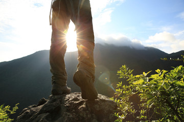 young woman hiker hiking on sunrise mountain peak