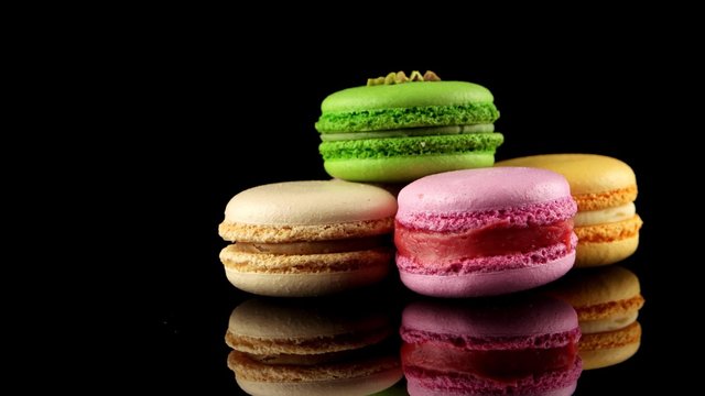 Traditional French colorful macarons on the black background
